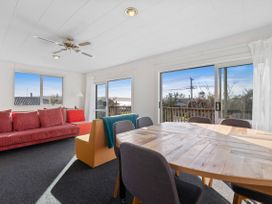 A living room with a sofa and dining area at Rotorua Holiday Home in Rotorua