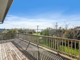 A deck with a view of grass and trees at Rotorua Holiday Home in Rotorua