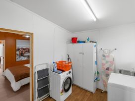 A laundry room with a washing machine and storage at Rotorua