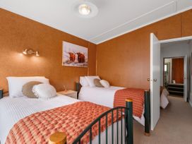 A bedroom with two beds and a painting on the wall at Rotorua