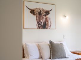 A bedroom with a bed and wall art at Rotorua