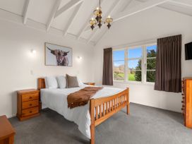 A bedroom with a bed and nightstands at Rotorua in Rotorua