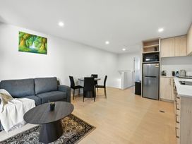 A living room with a sofa and dining area at Central Crossing - Christchurch Holiday Home, Christchurch