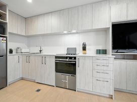 A kitchen with cabinets and appliances at Central Crossing - Christchurch Holiday Home, Christchurch
