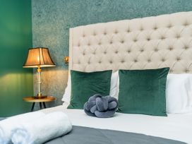 A bedroom with a bed and bedside lamp at Creed Cottage - Whitianga Holiday Home in Whitianga
