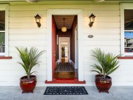 A doorway with potted plants and a lantern at Creed Cottage - Whitianga Holiday Home Whitianga