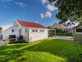 A house with a deck and furniture at Creed Cottage - Whitianga Holiday Home Whitianga