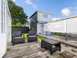 An outdoor seating area with chairs and a table at Creed Cottage - Whitianga Holiday Home in Whitianga