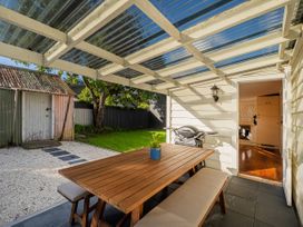 An outdoor dining area with a table and bench at Creed Cottage - Whitianga Holiday Home, Whitianga
