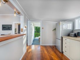 A kitchen featuring a fridge and counter at Creed Cottage - Whitianga Holiday Home in Whitianga
