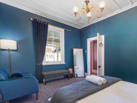 A bedroom with a bed and towels at Creed Cottage - Whitianga Holiday Home