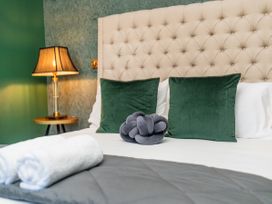 A bedroom with a bed and pillows at Creed Cottage - Whitianga Holiday Home