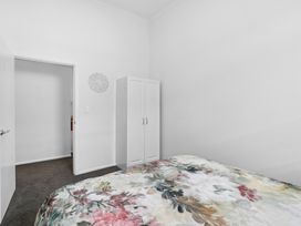 A bedroom with a bed and wardrobe at Arbor Villa - Greytown Holiday Home