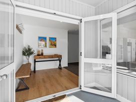 An entrance area with a table and wall art at Arbor Villa - Greytown Holiday Home