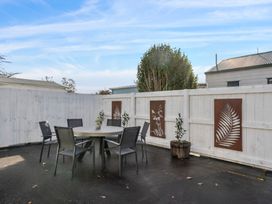 An outdoor seating area with a table and chairs at Arbor Villa - Greytown Holiday Home Greytown