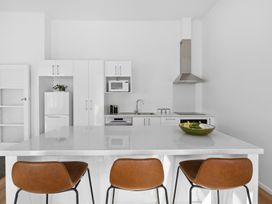 A kitchen with appliances and island seating at Arbor Villa - Greytown Holiday Home