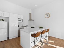 A kitchen with modern appliances and seating at Arbor Villa - Greytown