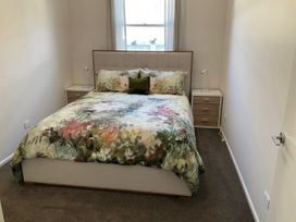A bedroom with a bed and bedside tables at Arbor Villa - Greytown Holiday Home in Greytown