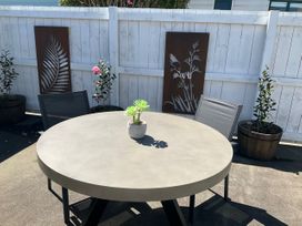 A round table with chairs and plants in an outdoor area at Arbor Villa - Greytown Holiday Home Greytown