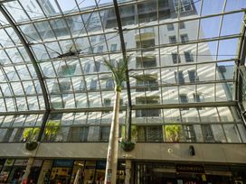 An indoor photo showing a glass roof with palm trees and storefronts at Downtown Haven - Christchurch Holiday Apartment in Christchurch