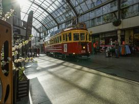 An indoor shopping area with a tram and flower display at Downtown Haven - Christchurch Holiday Apartment, Christchurch