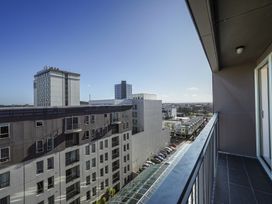 A balcony view overlooking buildings and a street at Downtown Haven - Christchurch Holiday Apartment Christchurch