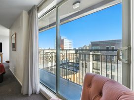 A living room with a balcony view at Downtown Haven - Christchurch Holiday Apartment in Christchurch