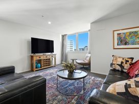 A living room with a television and sofa at Downtown Haven - Christchurch Holiday Apartment Christchurch