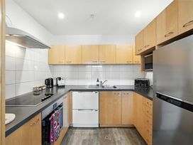 A kitchen with appliances and cabinets at Downtown Haven - Christchurch Holiday Apartment Christchurch