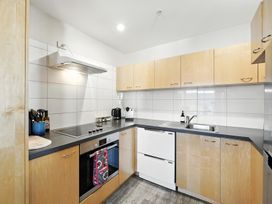 A kitchen with cooking range and sink at Downtown Haven - Christchurch Holiday Apartment in Christchurch