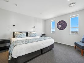 A bedroom with a bed and window views at Downtown Haven - Christchurch Holiday Apartment Christchurch