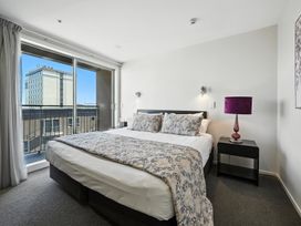 A bedroom with a bed and bedside table at Downtown Haven - Christchurch Holiday Apartment, Christchurch