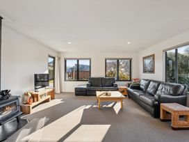 A living room with sofas and television at Vista Vale - Wanaka Holiday Home