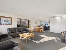 A living room with a sofa and dining area at Vista Vale - Wanaka Holiday Home