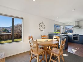 A dining room with a round table and chairs at Vista Vale - Wanaka Holiday Home