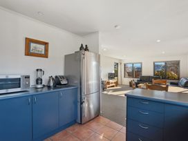 A kitchen with appliances and a dining area at Vista Vale - Wanaka Holiday Home