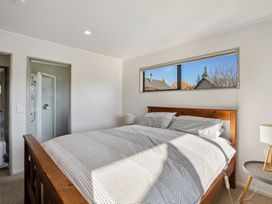 A bedroom with a bed and window at Vista Vale - Wanaka Holiday Home