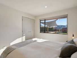 A bedroom with a bed and window at Vista Vale - Wanaka Holiday Home