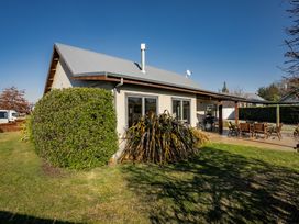 A house with a garden and outdoor seating at Vista Vale - Wanaka Holiday Home