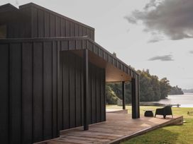A house with a porch and deck overlooking water at Lake Rotoiti in Rotorua