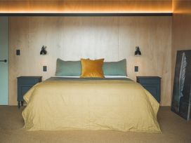 A bedroom with a bed and nightstands at Lake Rotoiti in Rotorua