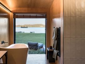 A bathroom with a bathtub and view of a lake at Lake Rotoiti in Rotorua