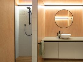 A bathroom with a shower and washbasin at Lake Rotoiti in Rotorua