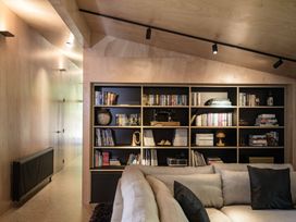 A living room with a bookshelf and sofa at Lake Rotoiti in Rotorua