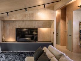 A living room with a television and sofa at Lake Rotoiti in Rotorua