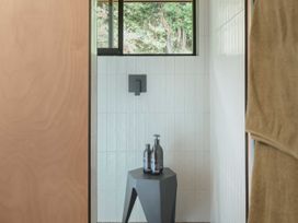 A bathroom with a shower and various toiletries at Lake Rotoiti in Rotorua