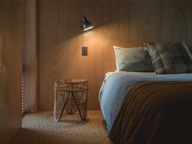A bedroom with a bed and a lamp at Lake Rotoiti in Rotorua