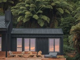 A building with windows and chairs at Lakefront Luxury at Okere Falls Lake Rotoiti