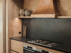A kitchen with a stove and a copper range hood at Lakefront Luxury at Okere Falls Lake Rotoiti