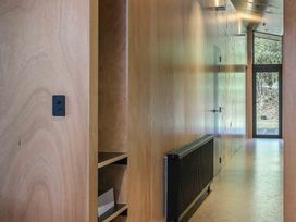 A hallway with a door and shelving at Lakefront Luxury at Okere Falls Lake Rotoiti